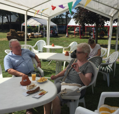 Zwei Personen sitzen im Schatten und betrachten das Treiben